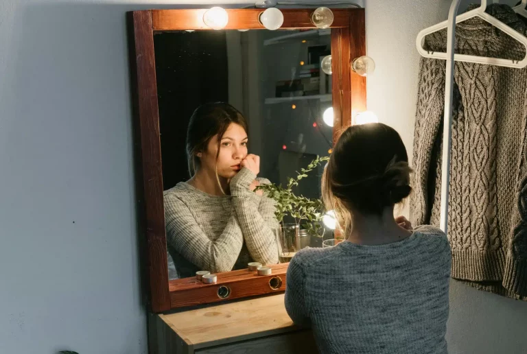 chica viéndose al espejo con cara de culpa